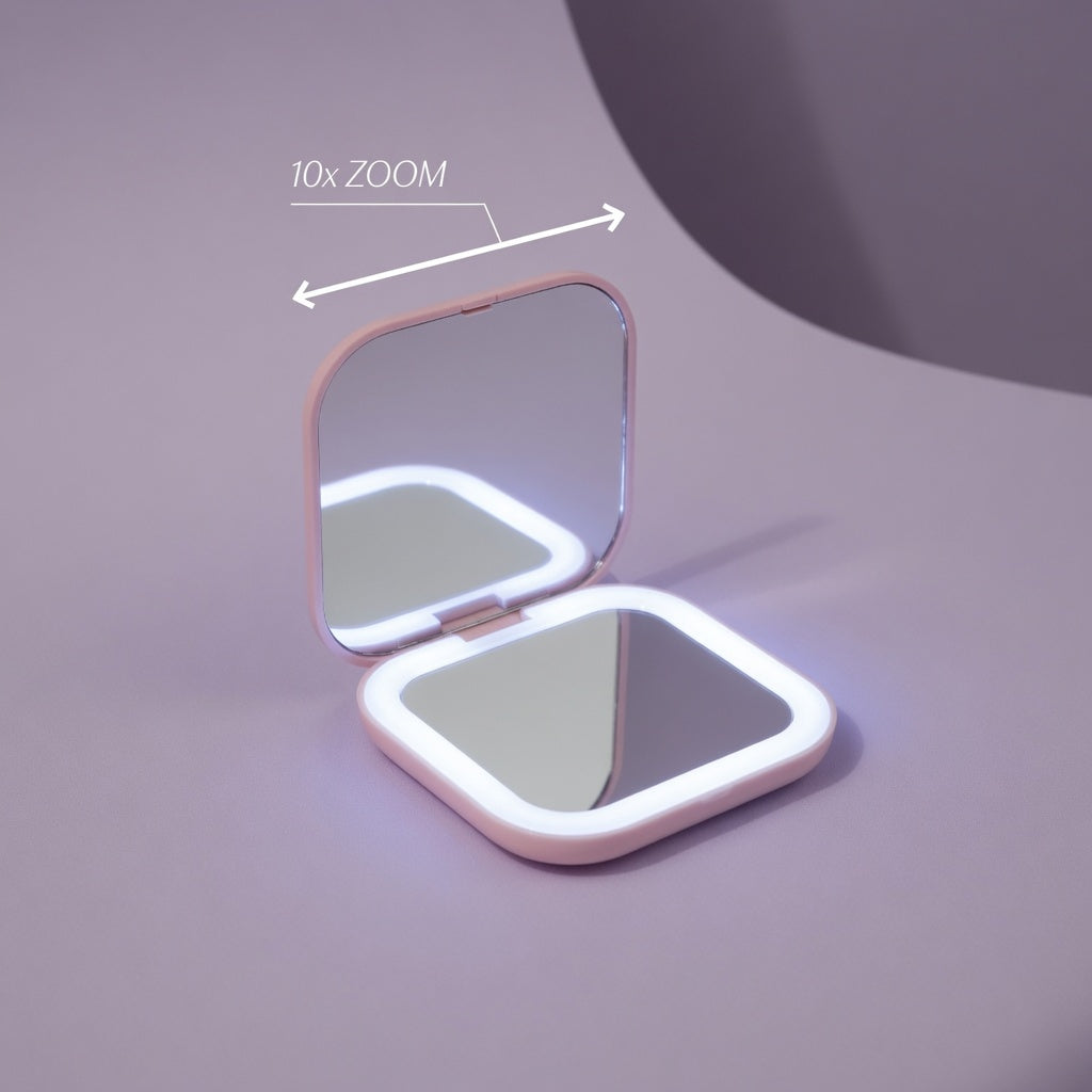 Compact mirror with LED lighting on a purple background showing the zoom in power till 10X