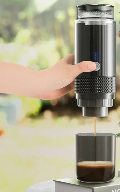 Portable coffee maker brewing espresso at a sunny campsite with mountains in the background.
