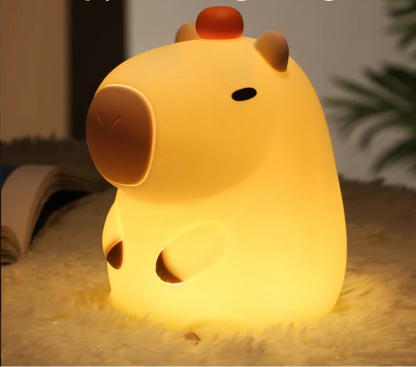 Capybara night light, lit on a soft surface with setting memory .