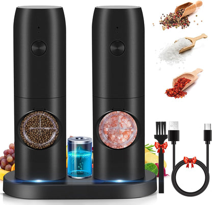 Two black salt and pepper grinders with additional items like charging cable, charging base and cleaning brush.